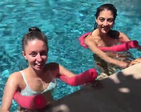 Two Bikini Teens challenging each other in pool