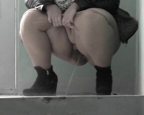 Mature bbw milf pissing in a public entrance.